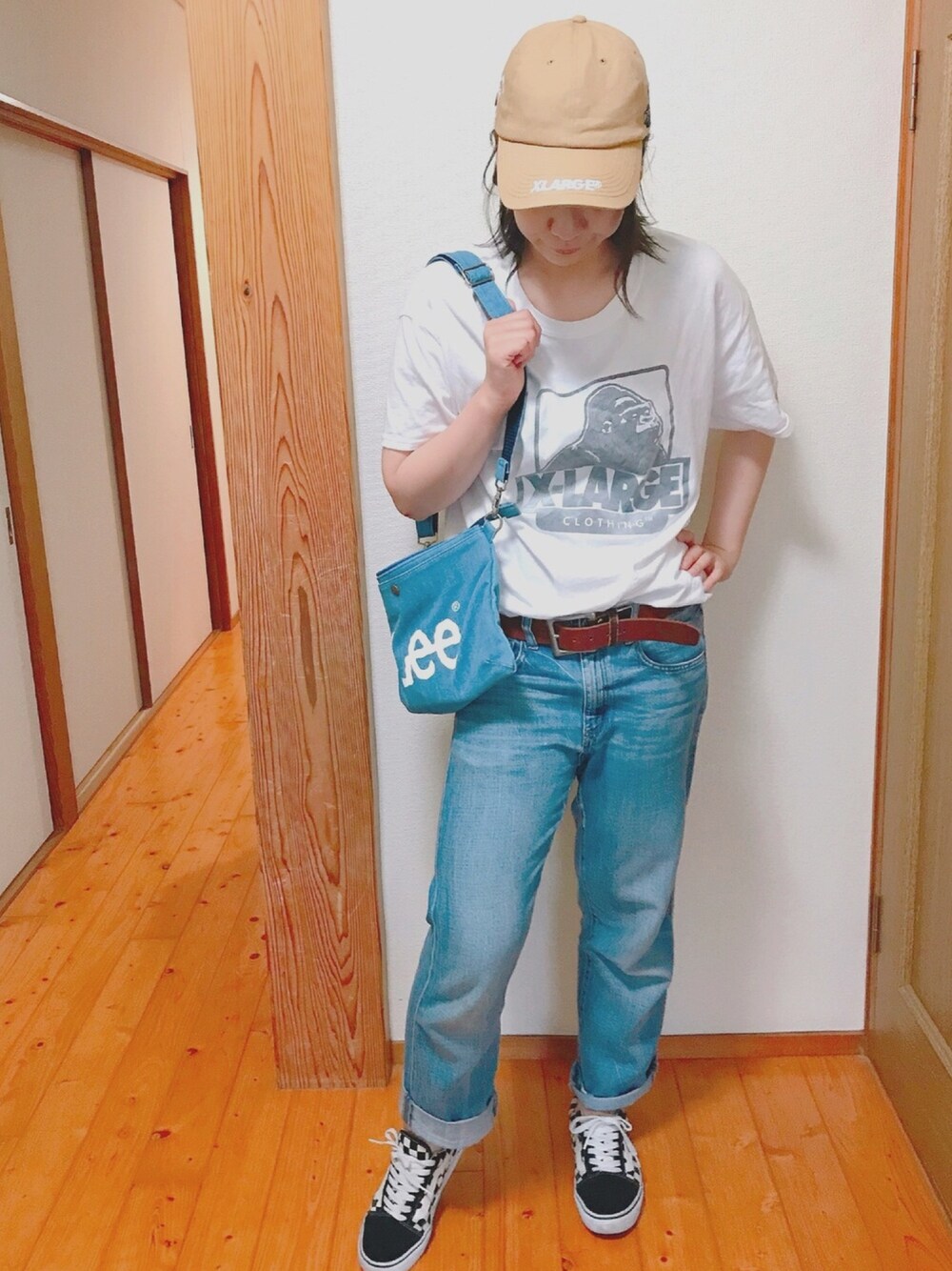 ブルー系のショルダーバッグ、ホワイト系のTシャツ/カットソー、ブルー系のデニムパンツを着用したレディースの春コーディネートの1枚目の写真