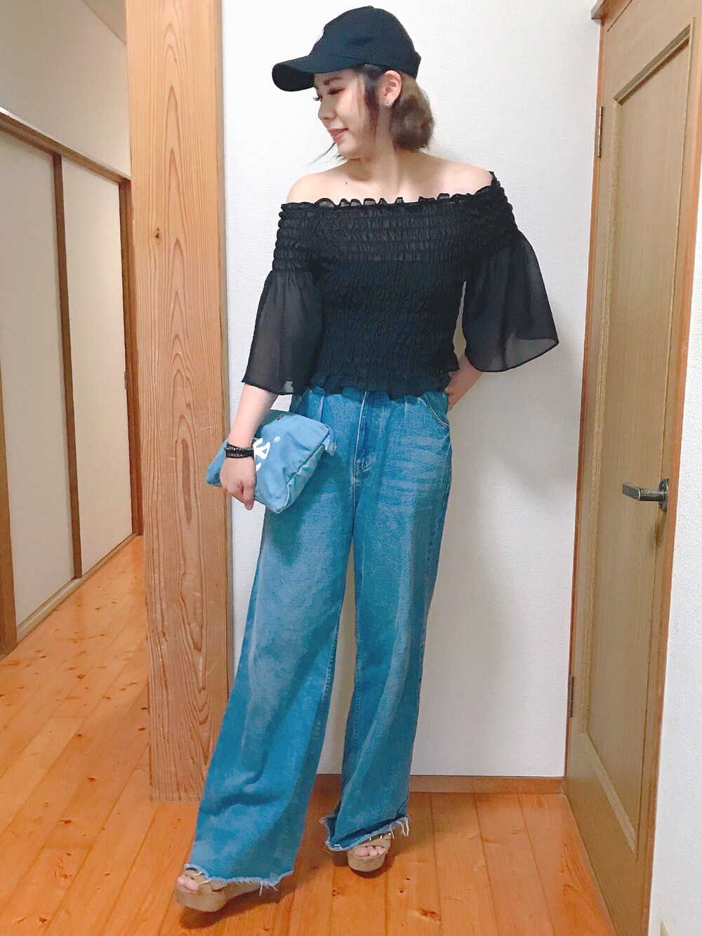 ブルー系のデニムパンツ、ブラック系のシャツ/ブラウス、ブルー系のショルダーバッグを着用したレディースの夏コーディネートの1枚目の写真