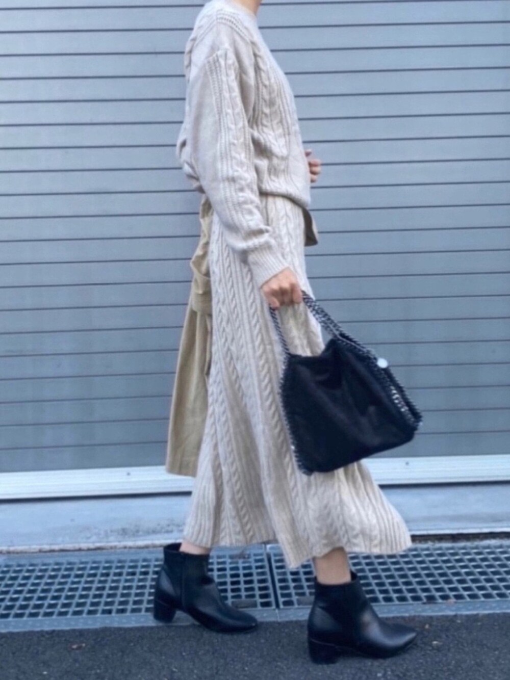 ブラック系のショルダーバッグ、ブラック系のブーツ、ベージュ系のセットアップを着用したレディースの秋コーディネートの1枚目の写真