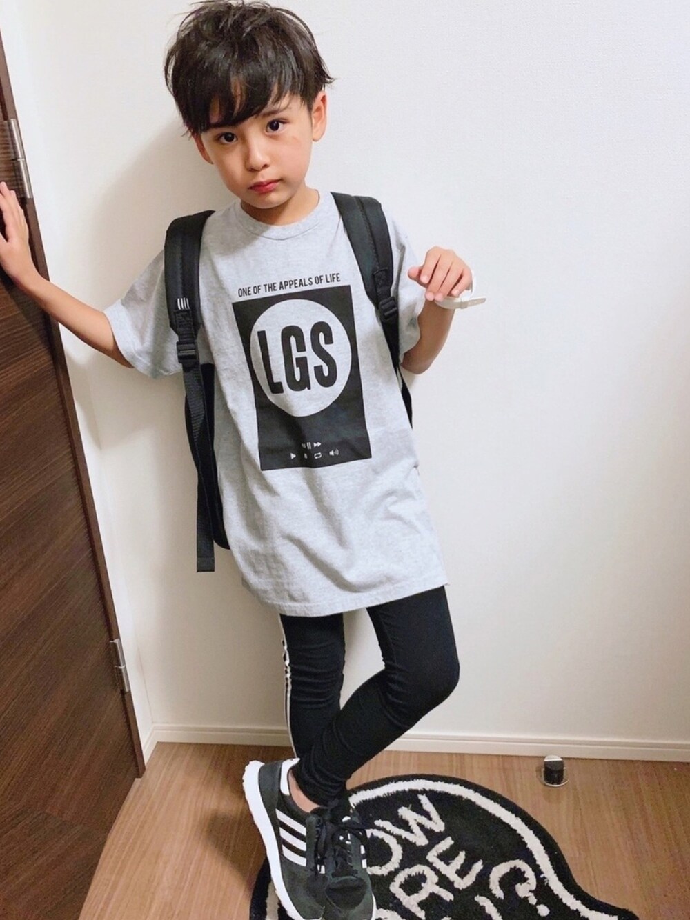 グレー系のTシャツ/カットソー、ブラック系のバックパック/リュック、ブラック系のスニーカーを着用したキッズの夏コーディネートの1枚目の写真