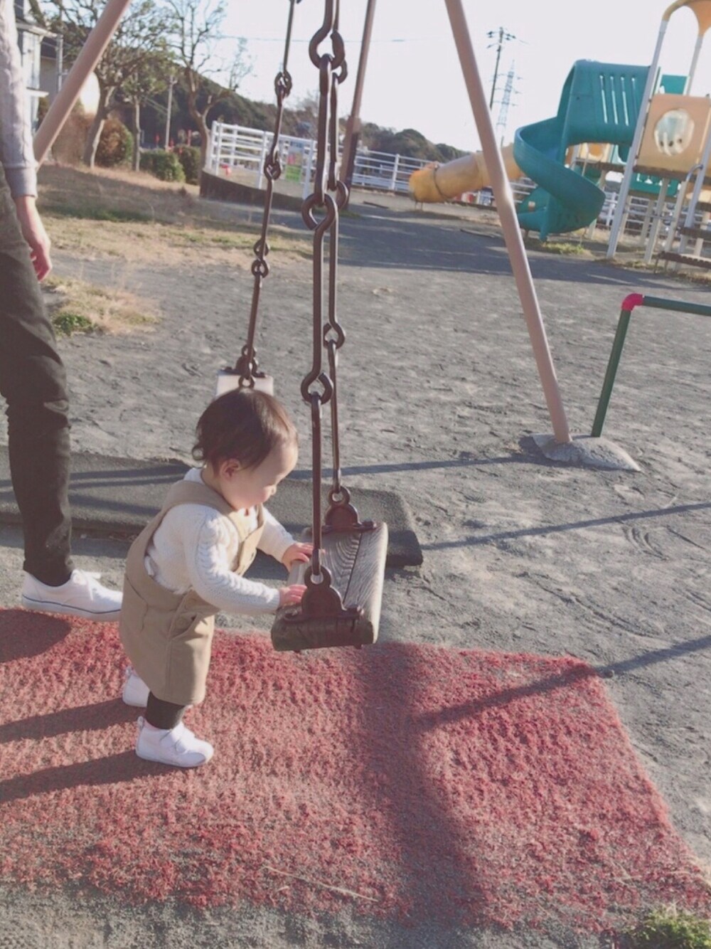 ホワイト系のニット/セーター、ベージュ系のサロペット/オーバーオール、ホワイト系のスニーカーを着用したキッズの冬コーディネートの1枚目の写真