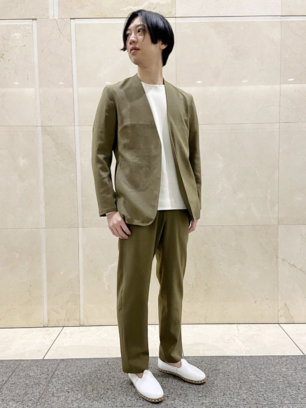 グリーン系のノーカラージャケット、ホワイト系のニット/セーター、グリーン系のその他パンツを着用したメンズの春コーディネートの1枚目の写真