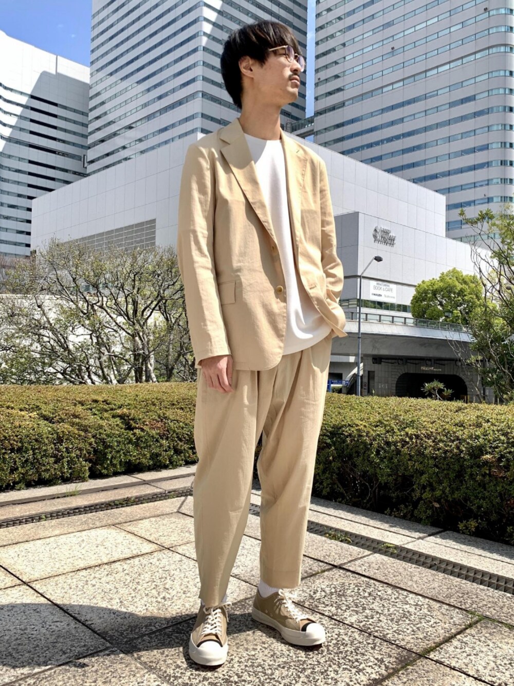 ベージュ系のテーラードジャケット、ベージュ系のスラックス、ホワイト系のTシャツ/カットソーを着用したメンズの春コーディネートの1枚目の写真