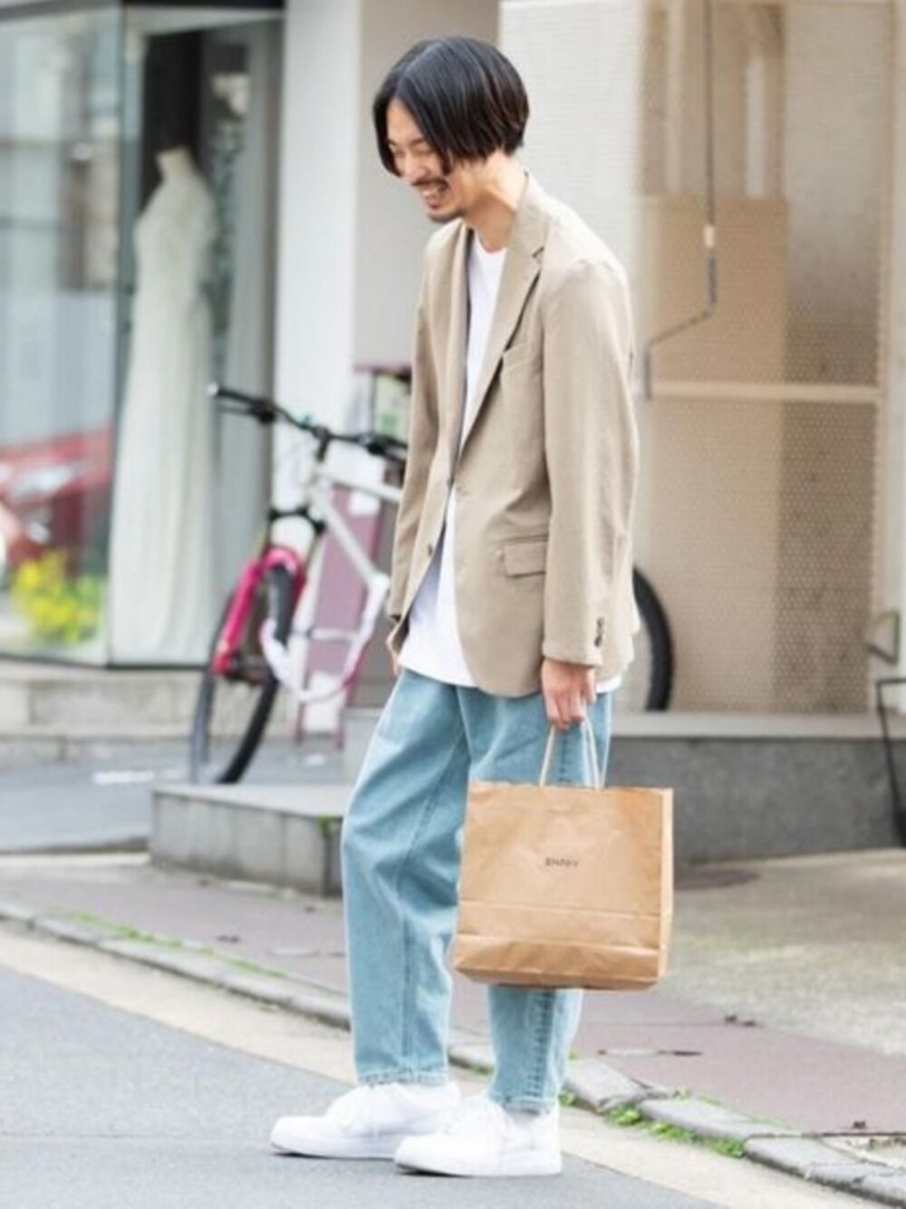 ベージュ系のセットアップ、ブルー系のデニムパンツ、ホワイト系のスニーカーを着用したメンズの春コーディネートの1枚目の写真