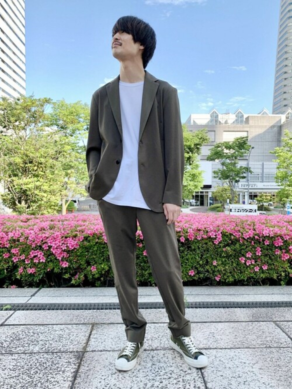 グリーン系のテーラードジャケット、グリーン系のスラックスを着用したメンズの夏コーディネートの1枚目の写真