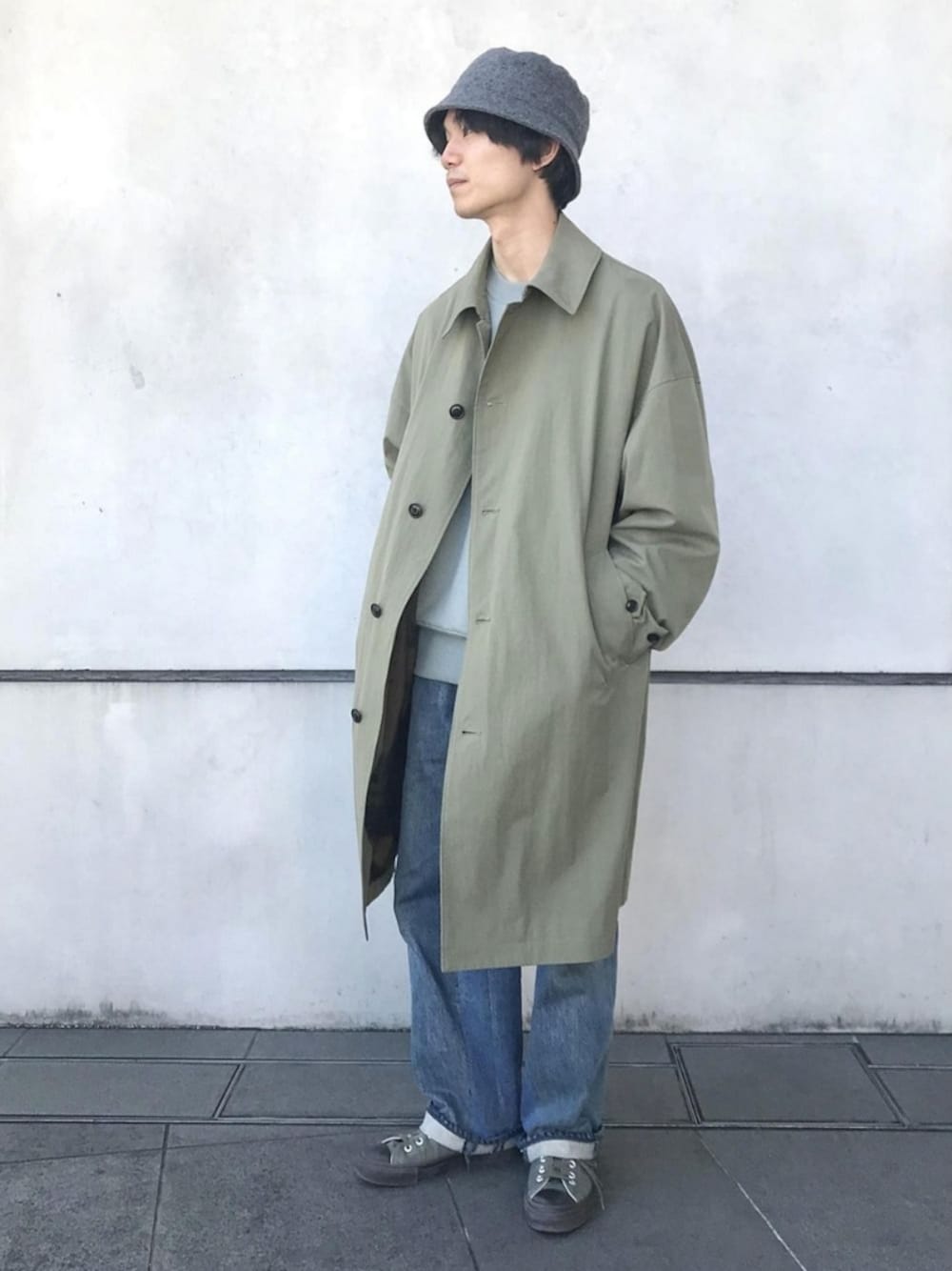 グリーン系のステンカラーコートを着用したメンズの冬コーディネートの1枚目の写真