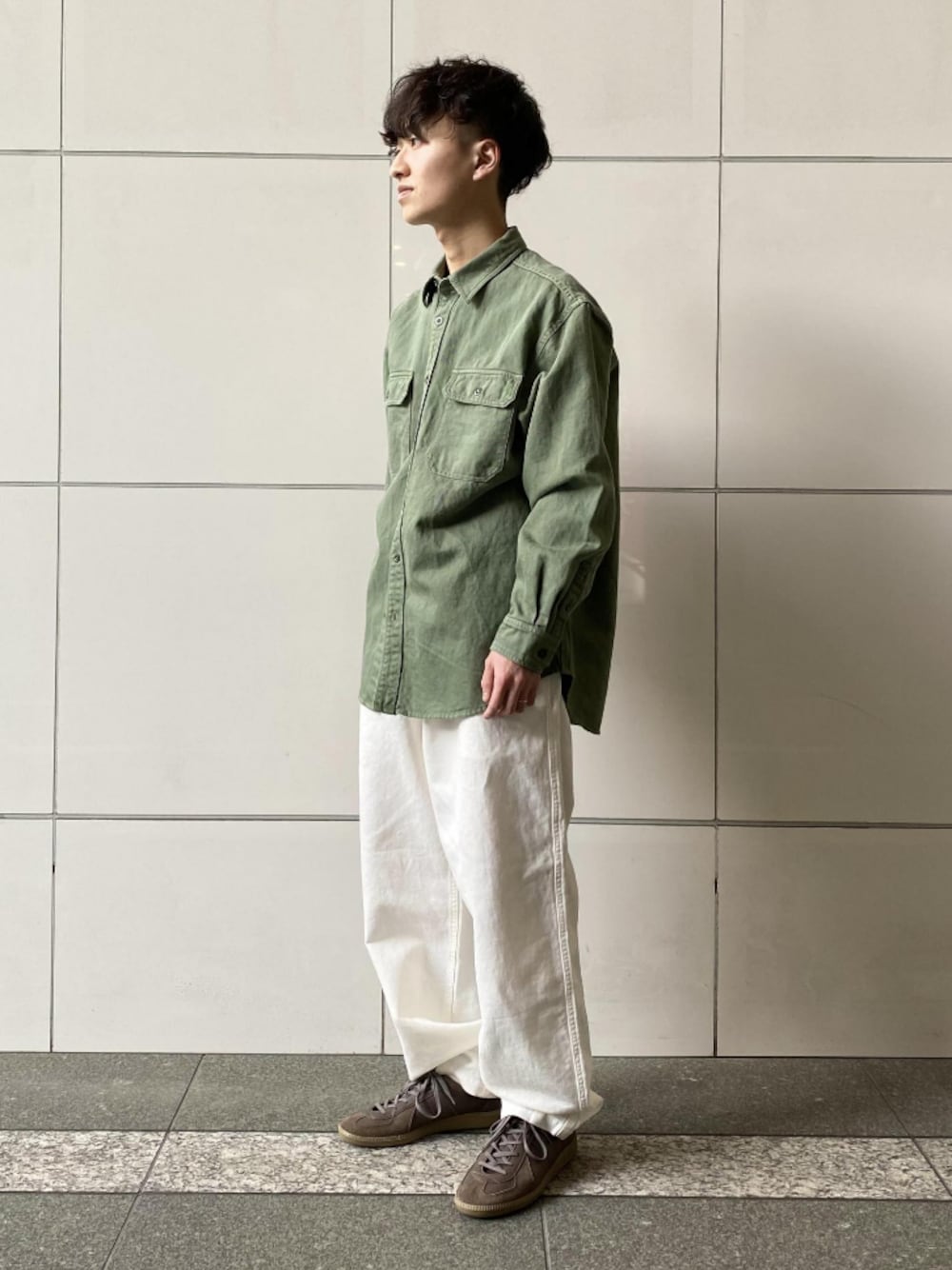 グリーン系のシャツ/ブラウス、ホワイト系のパンツ、グレー系のスニーカーを着用したメンズの春コーディネートの1枚目の写真