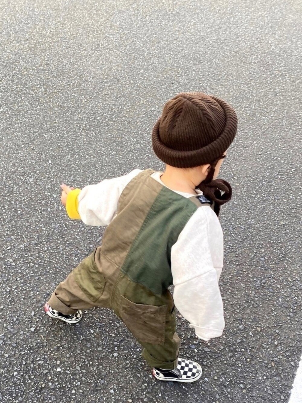 グリーン系のサロペット/オーバーオール、イエロー系のシャツ/ブラウス、ブラック系のスニーカーを着用したキッズの冬コーディネートの1枚目の写真