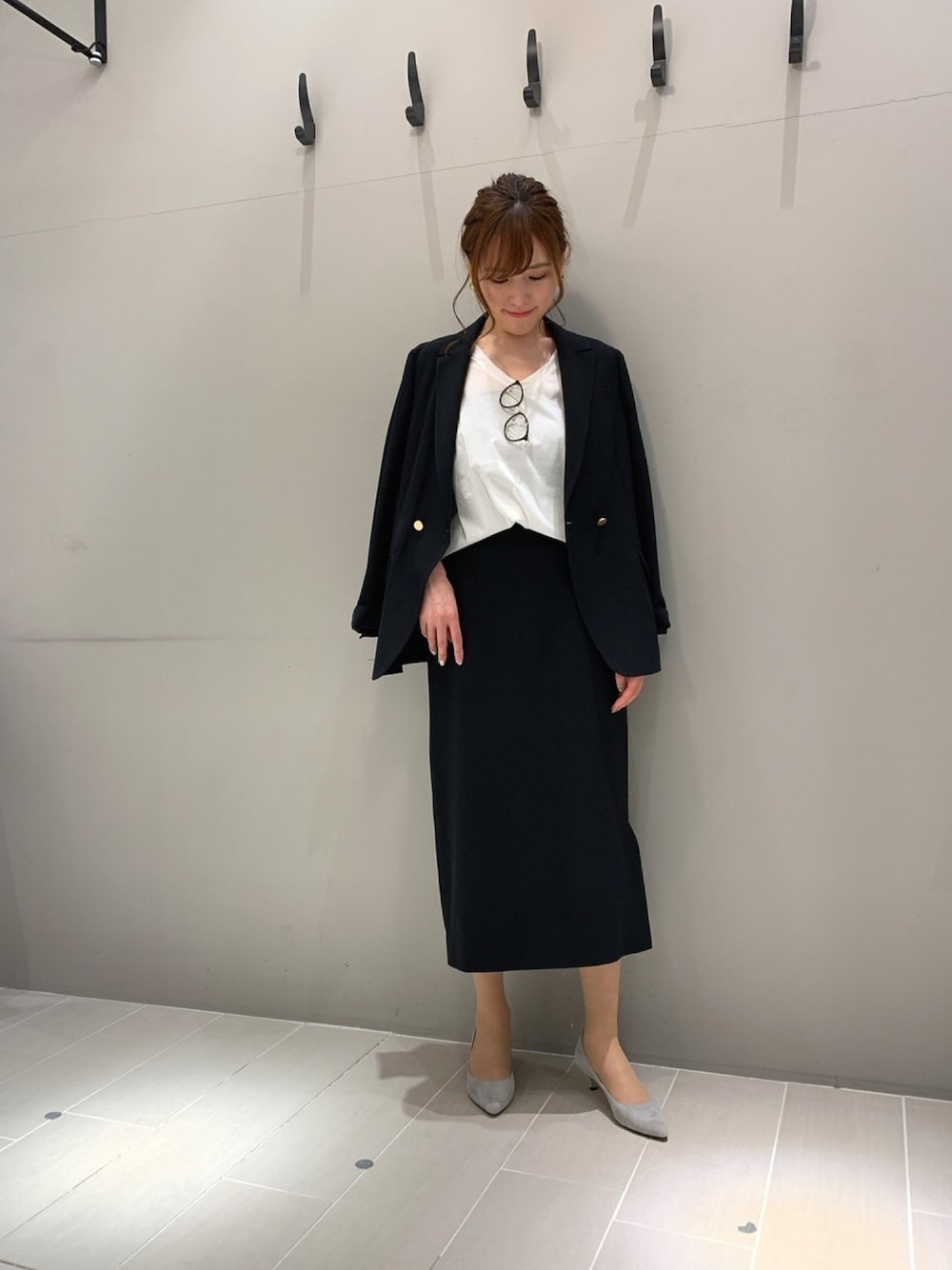 ブラック系のスカート、ブラック系のテーラードジャケット、ホワイト系のTシャツ/カットソーを着用したレディースの春コーディネートの1枚目の写真