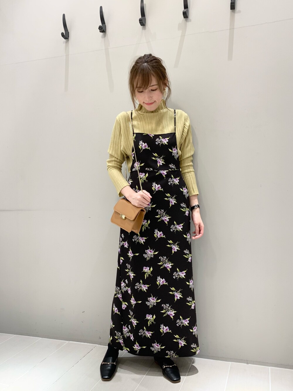 イエロー系のニット/セーター、ブラック系のワンピース、ブラック系のパンプスを着用したレディースの秋コーディネートの1枚目の写真