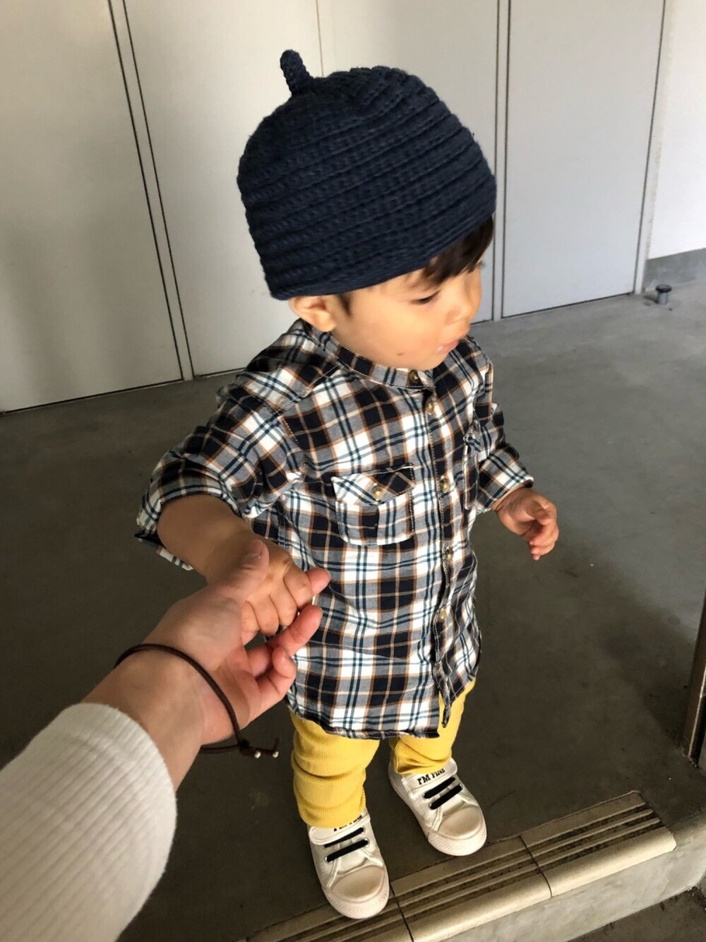 ブラウン系のシャツ/ブラウス、ホワイト系のスニーカー、イエロー系のその他ベビー用品を着用したキッズの春コーディネートの1枚目の写真