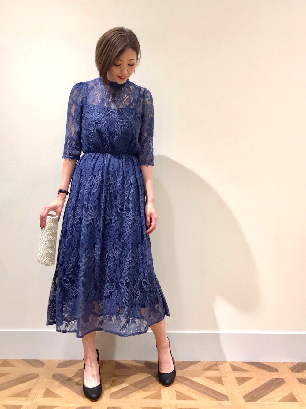 ブルー系のワンピース/ドレス、ベージュ系のクラッチバッグ、ブラック系のパンプスを着用したレディースの冬コーディネートの1枚目の写真