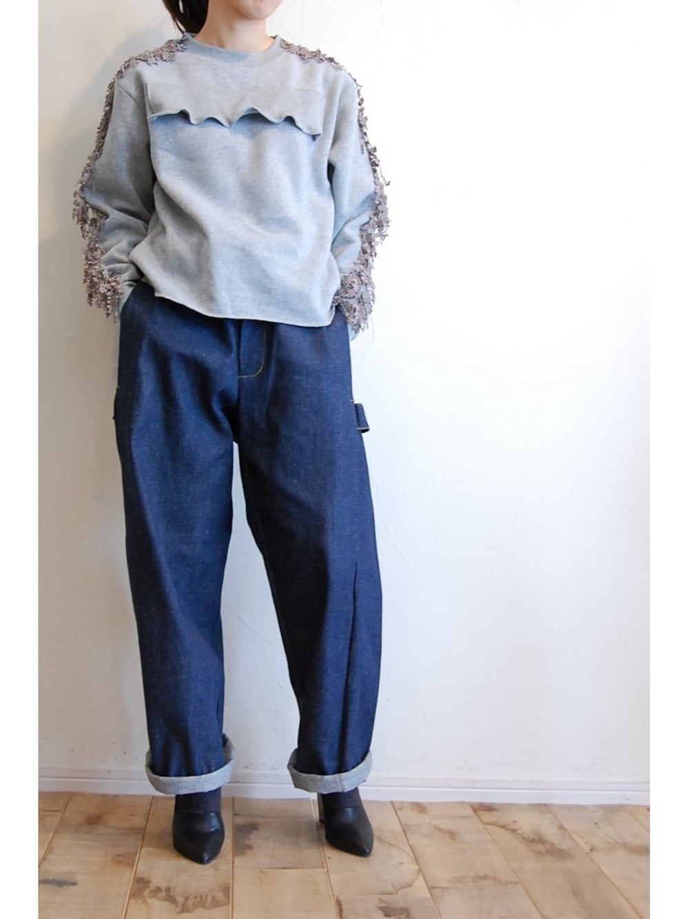 ブルー系のデニムパンツ、グレー系のスウェット、ブラック系のパンプスを着用したレディースの冬コーディネートの1枚目の写真