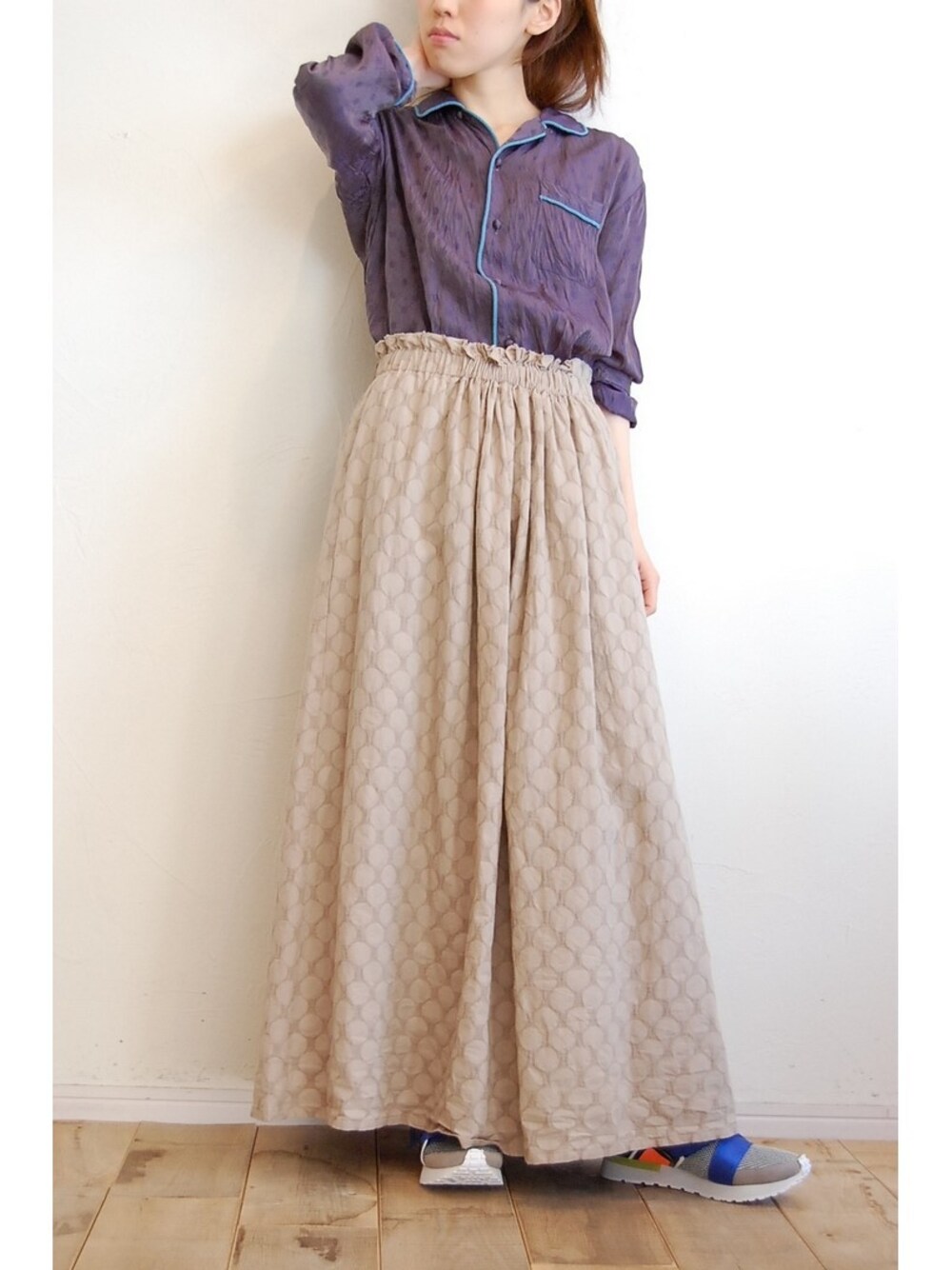 ブルー系のシャツ/ブラウス、ベージュ系のスカート、ブルー系のスニーカーを着用したレディースの春コーディネートの1枚目の写真