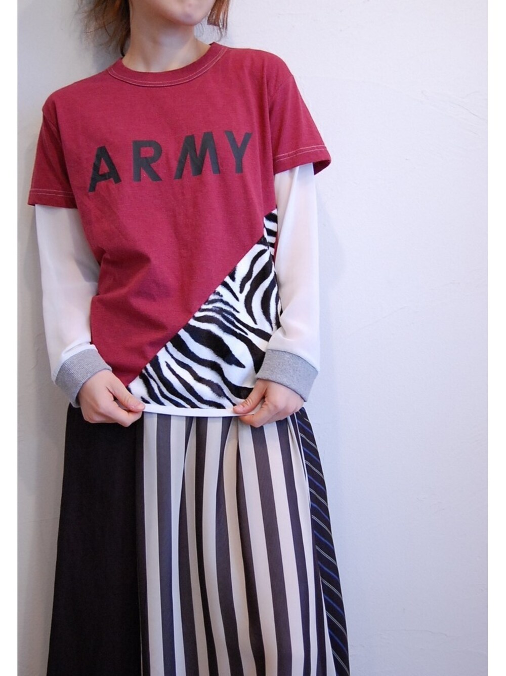 レッド系のTシャツ/カットソー、ブラック系のスカートを着用したレディースの春コーディネートの1枚目の写真