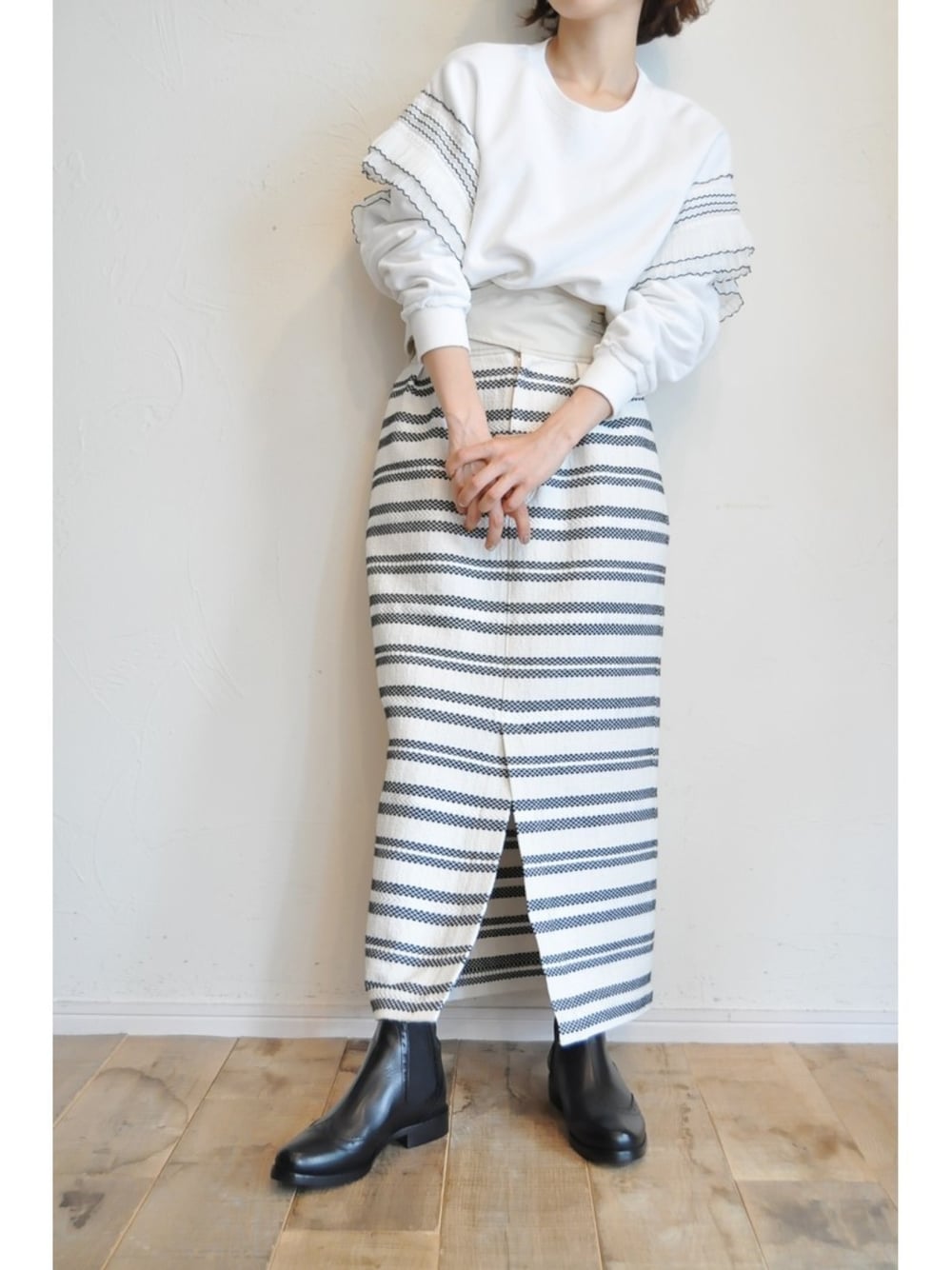 ホワイト系のTシャツ/カットソー、その他のスカート、ブラック系のブーツを着用したレディースの秋コーディネートの1枚目の写真