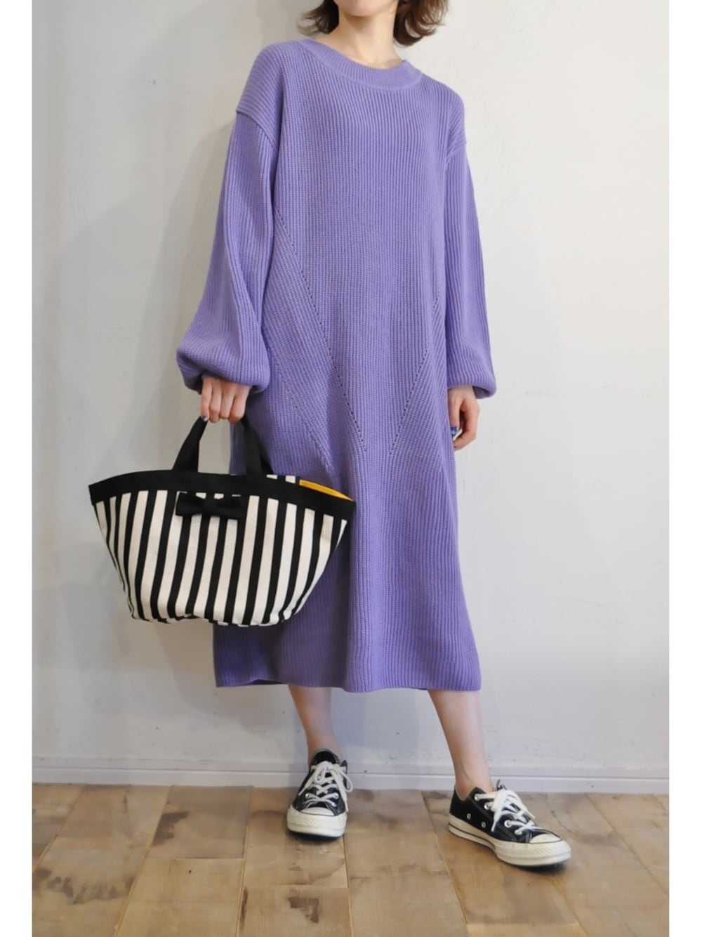 パープル系のワンピース、ホワイト系のハンドバッグを着用したレディースの冬コーディネートの1枚目の写真