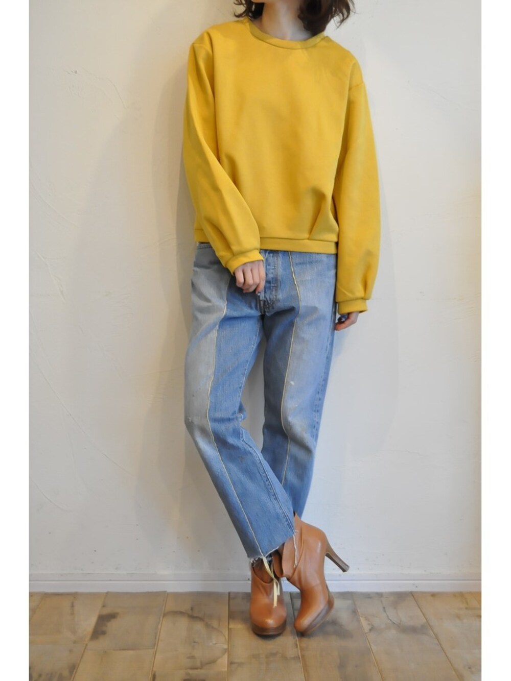 イエロー系のTシャツ/カットソー、ブルー系のデニムパンツを着用したレディースの冬コーディネートの1枚目の写真