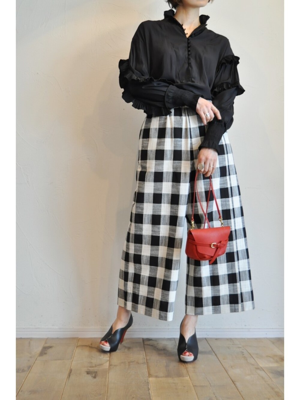 ブラック系のシャツ/ブラウス、ブラック系のその他パンツ、レッド系のショルダーバッグを着用したレディースの春コーディネートの1枚目の写真