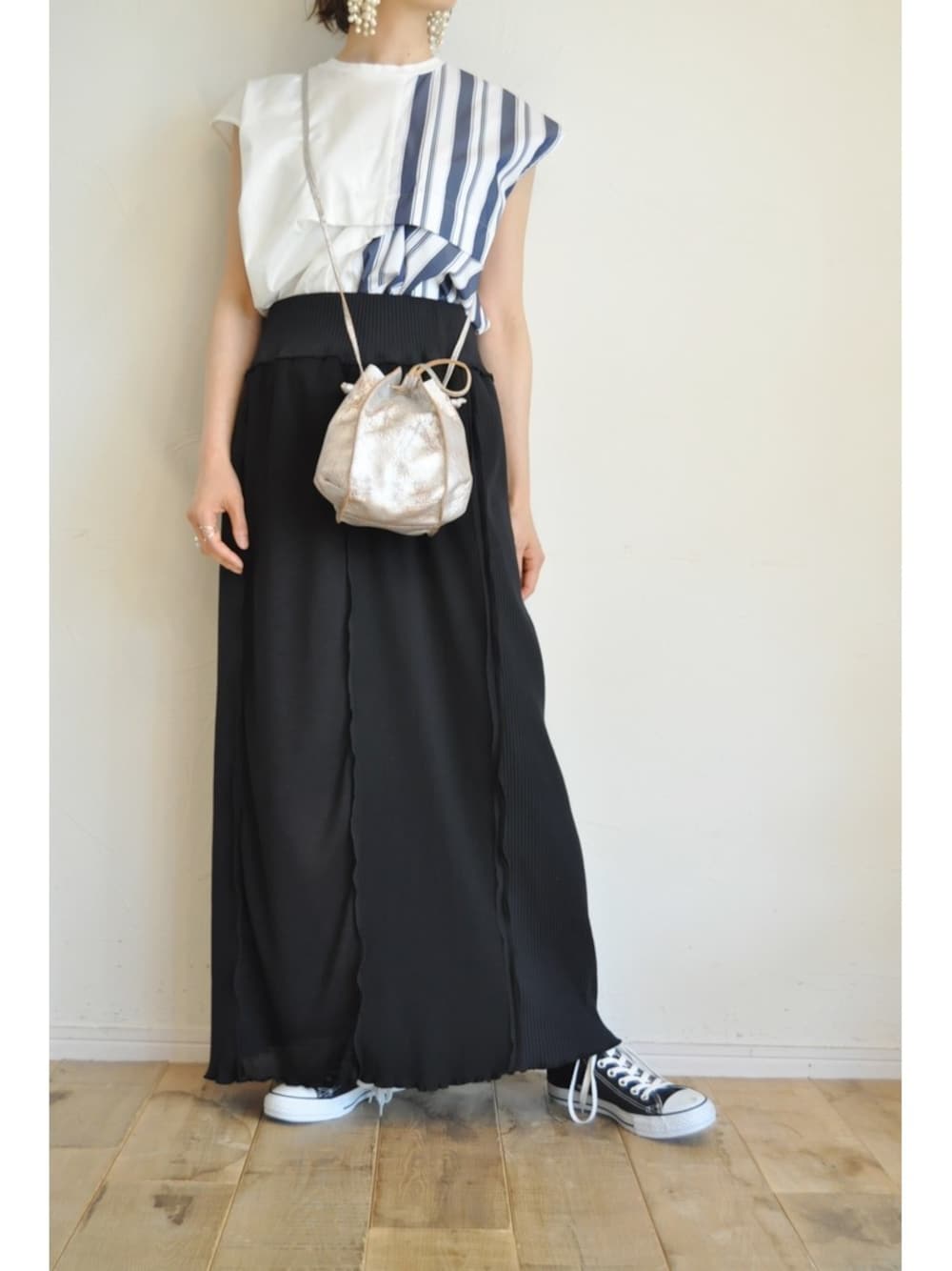 ゴールド系のサンダル、ホワイト系のTシャツ/カットソー、ブラック系のスカートを着用したレディースの春コーディネートの1枚目の写真