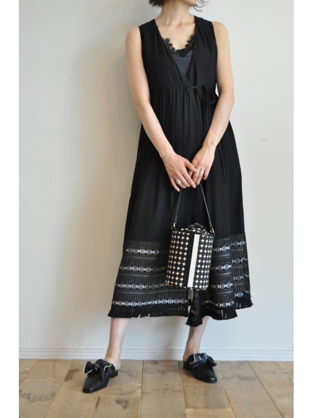 ブラック系のワンピース、ブラック系のハンドバッグ、ブラック系のパンプスを着用したレディースの春コーディネートの1枚目の写真