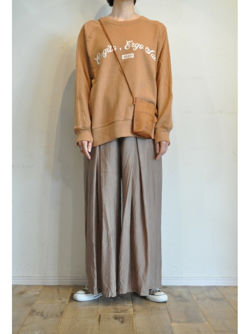 ブラウン系のその他パンツ、ベージュ系のスウェット、ブラウン系のショルダーバッグを着用したレディースの秋コーディネートの1枚目の写真