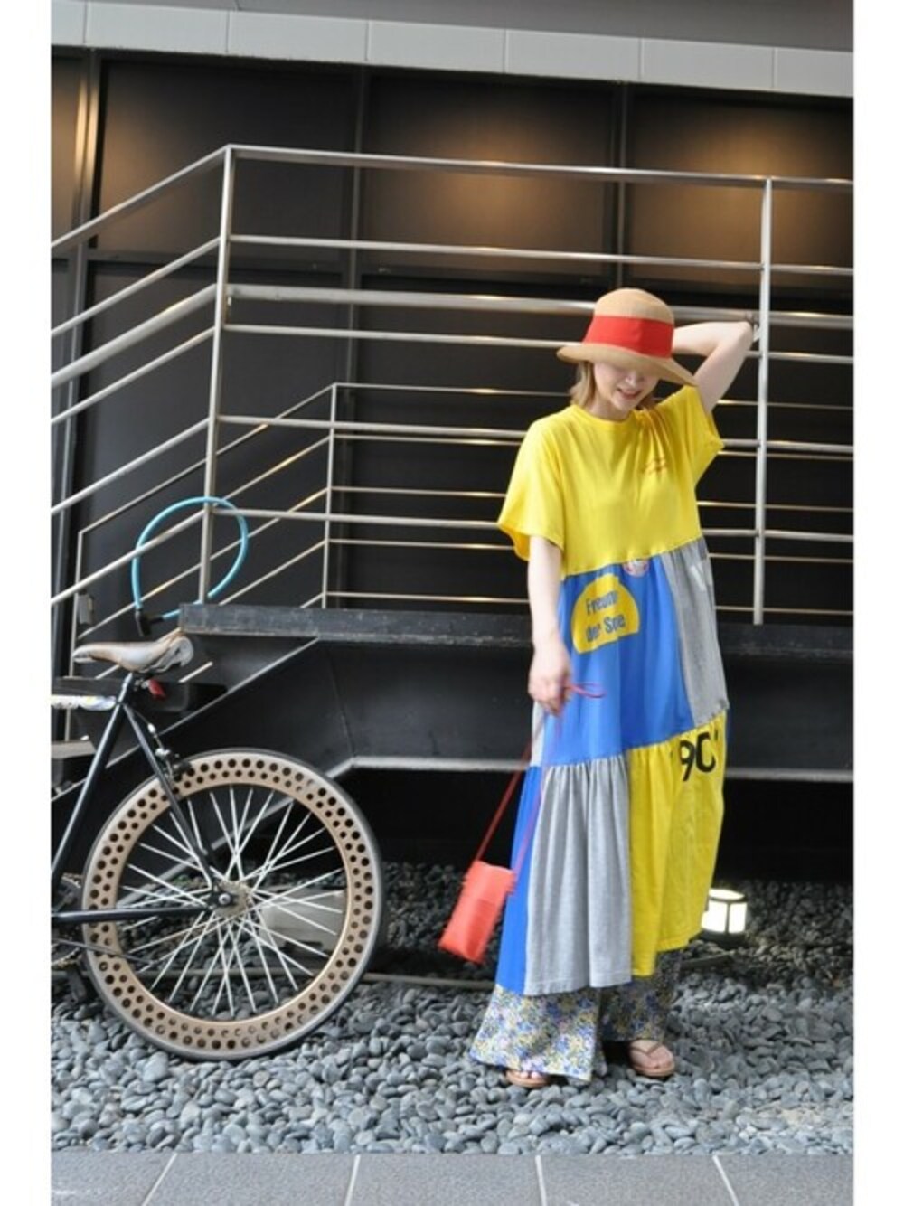 イエロー系のワンピース、ブルー系のその他パンツ、レッド系のポーチを着用したレディースの夏コーディネートの1枚目の写真