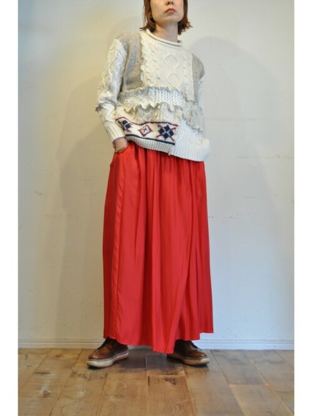 レッド系のその他パンツ、ベージュ系のニット/セーターを着用したレディースの秋コーディネートの1枚目の写真