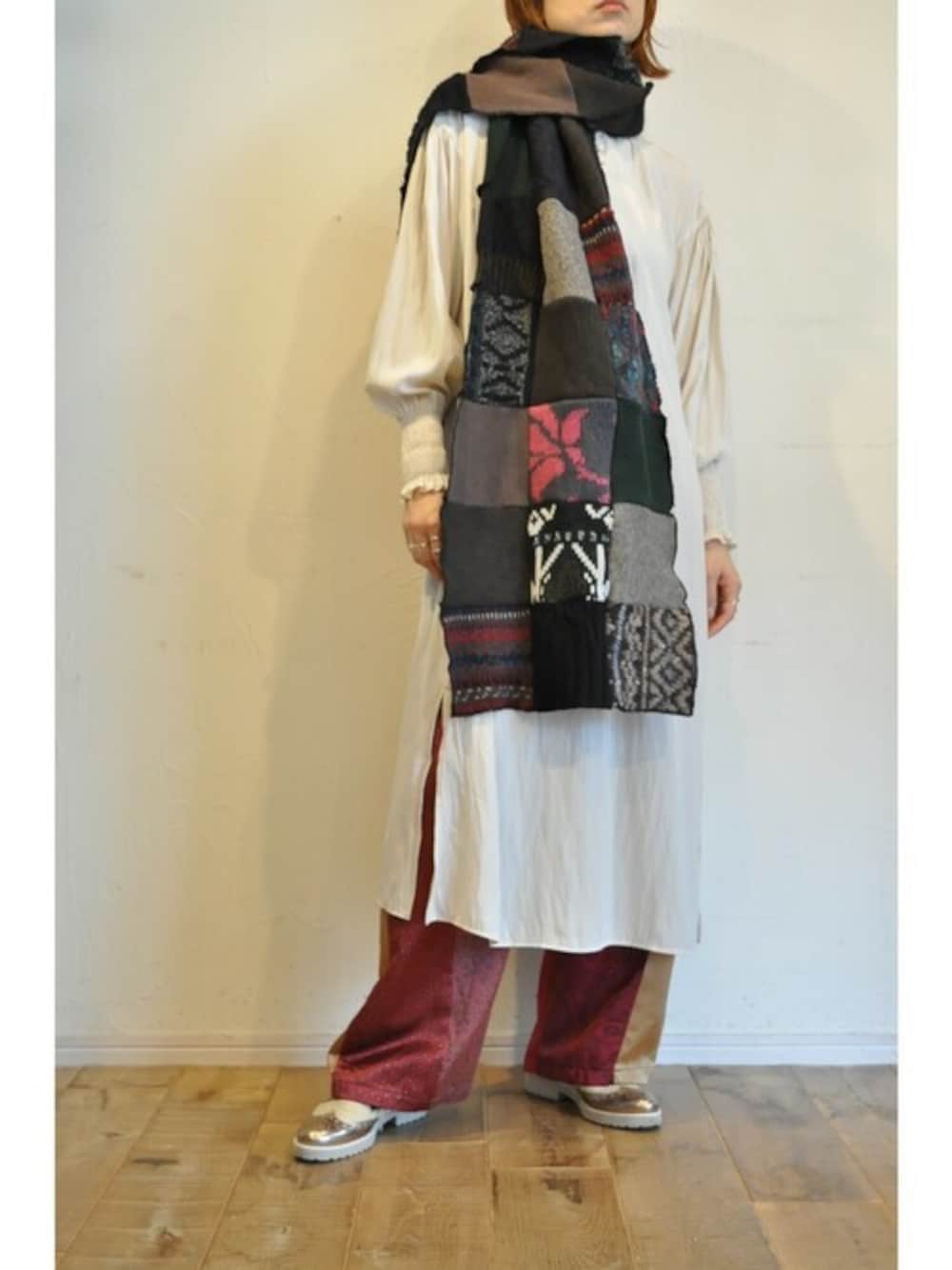 ベージュ系のワンピース、レッド系のその他パンツ、ブラック系のマフラーを着用したレディースの冬コーディネートの1枚目の写真