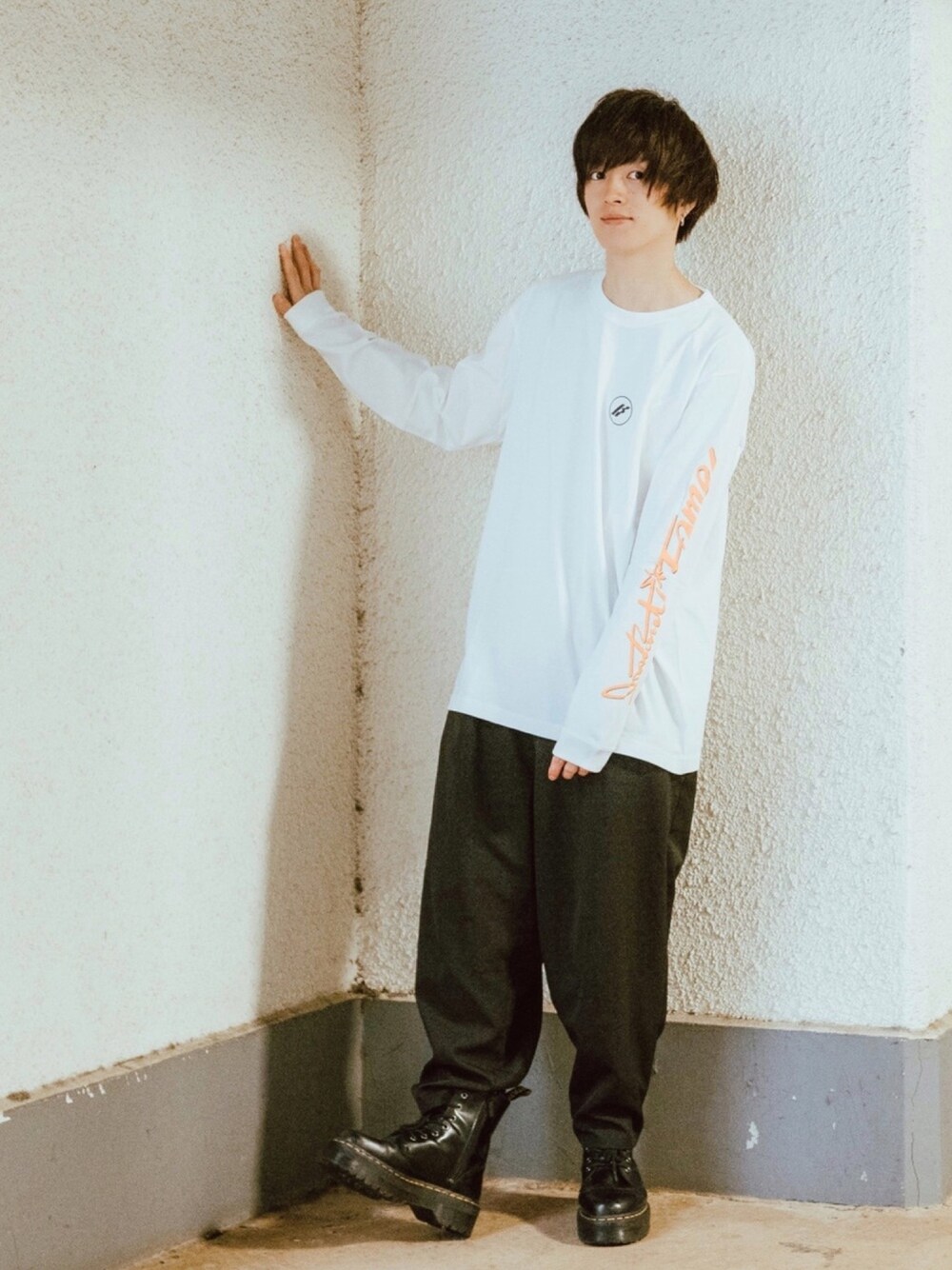 ブラック系のブーツ、ブラック系のスラックス、ホワイト系のTシャツ/カットソーを着用したメンズの春コーディネートの1枚目の写真