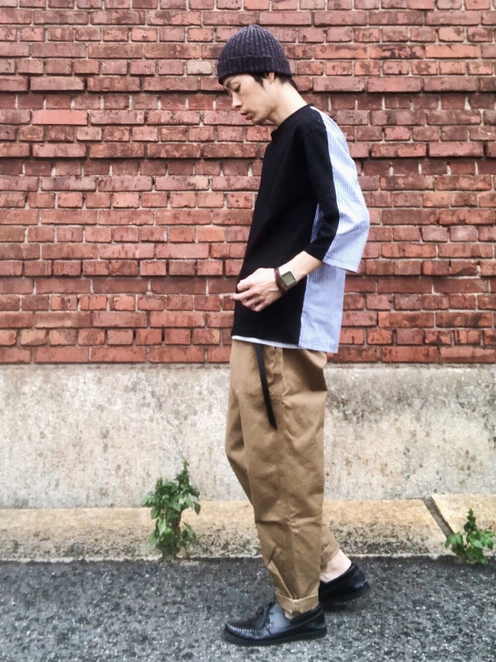 ブラック系のTシャツ/カットソー、ブラウン系のチノパンツ、ブラック系のモカシン/デッキシューズを着用したメンズの秋コーディネートの1枚目の写真