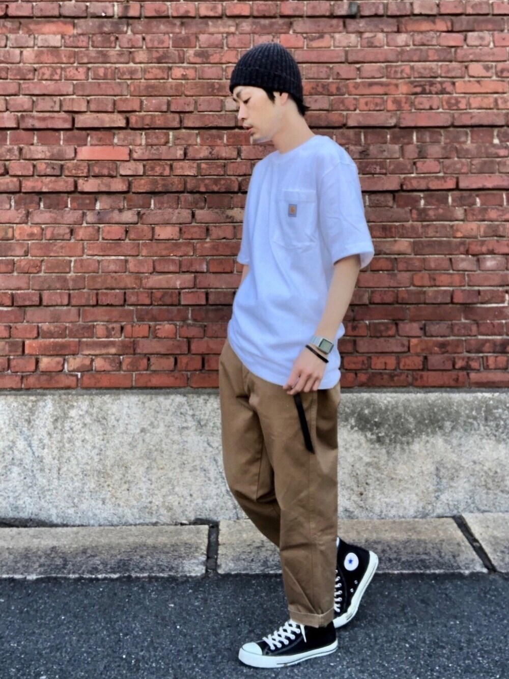 ホワイト系のTシャツ/カットソー、ブラウン系のチノパンツ、ブラック系のスニーカーを着用したメンズの春コーディネートの1枚目の写真