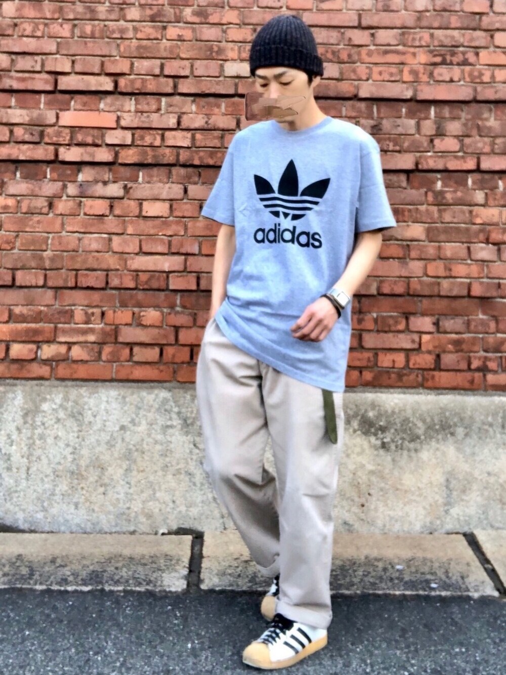 グレー系のTシャツ/カットソー、ベージュ系のチノパンツ、ホワイト系のスニーカーを着用したメンズの春コーディネートの1枚目の写真