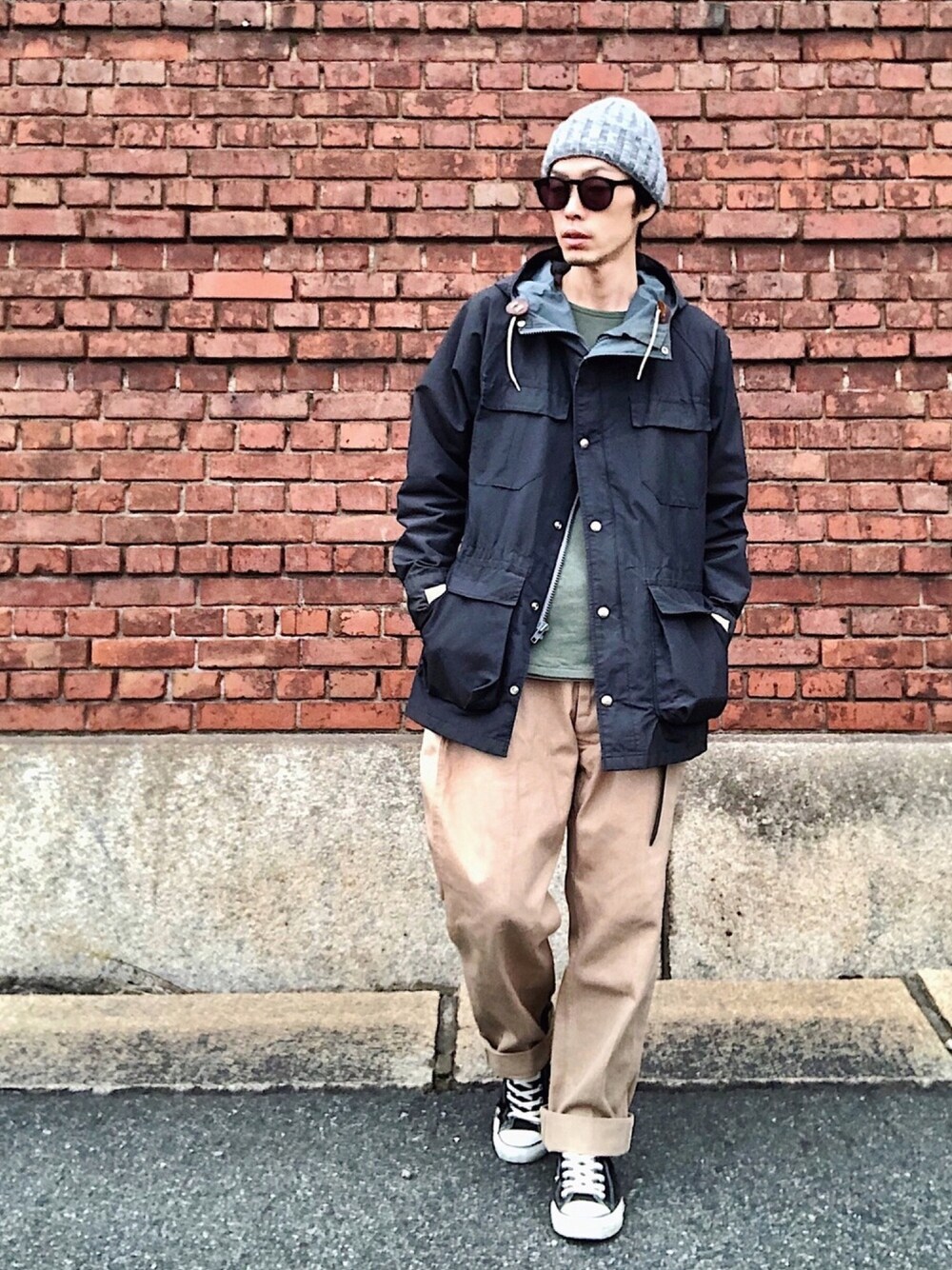 ブラック系のマウンテンパーカー、グリーン系のスウェット、グリーン系のチノパンツを着用したメンズの秋コーディネートの1枚目の写真