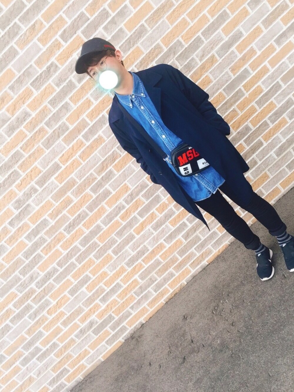 ブラック系のスニーカー、ブラック系のデニムパンツ、ブルー系のシャツ/ブラウスを着用したメンズの春コーディネートの1枚目の写真