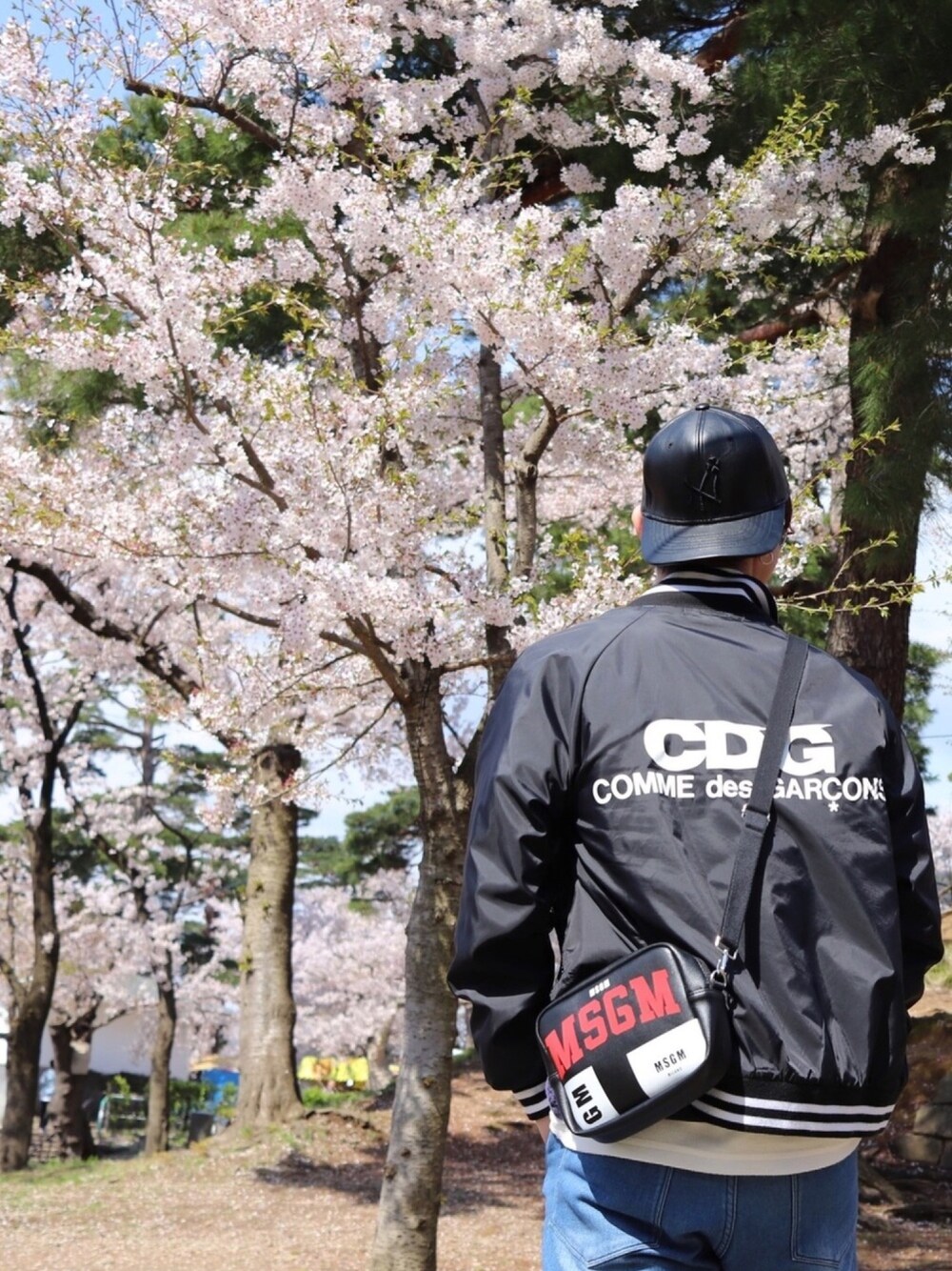 ブラック系のスニーカー、ブルー系のデニムパンツ、ホワイト系のTシャツ/カットソーを着用したメンズの春コーディネートの1枚目の写真
