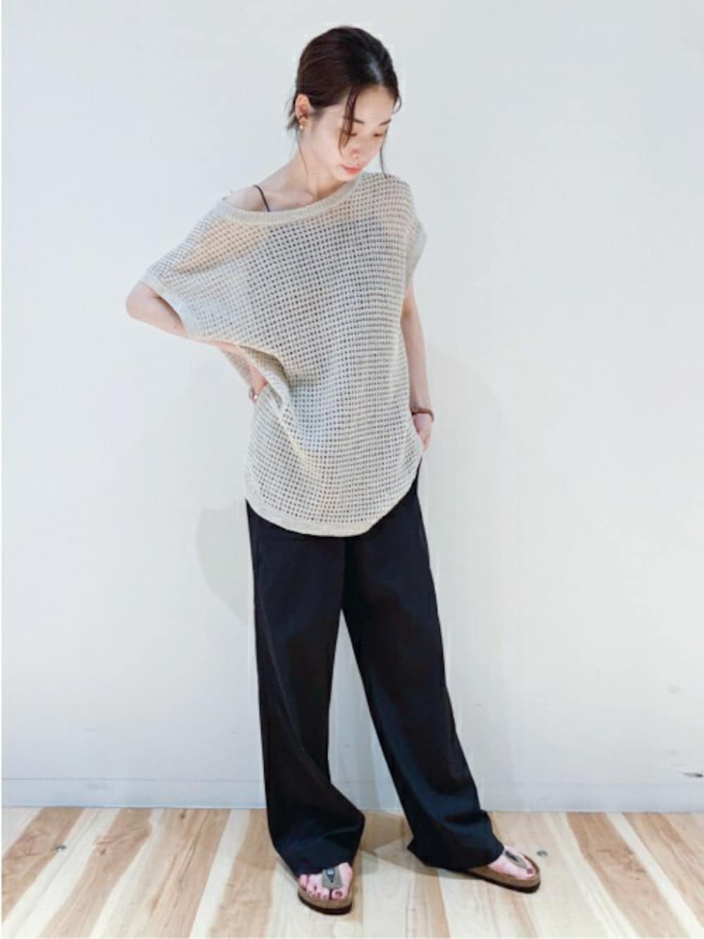 ホワイト系のニット/セーター、ブラック系のキャミソール、ベージュ系のサンダルを着用したレディースの夏コーディネートの1枚目の写真