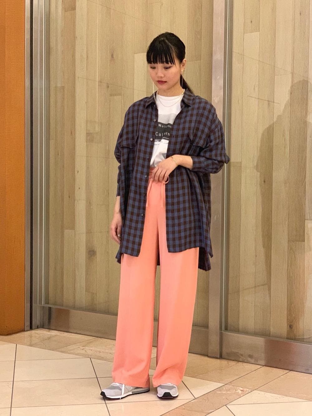 グレー系のスニーカー、ブルー系のシャツ/ブラウス、ホワイト系のTシャツ/カットソーを着用したレディースの冬コーディネートの1枚目の写真