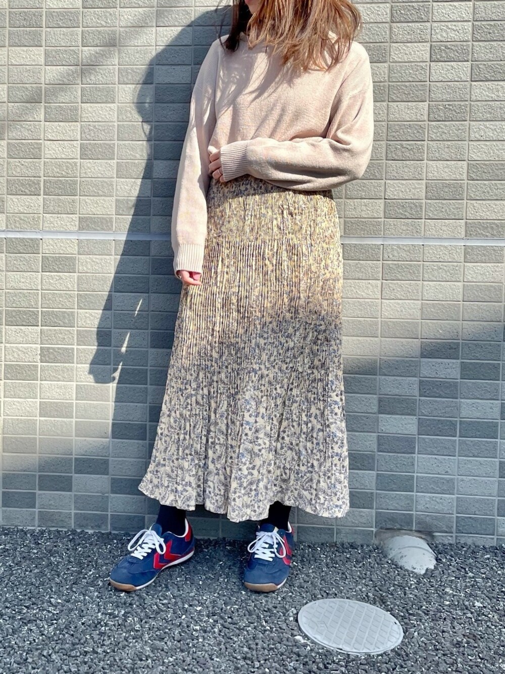 ブルー系のスニーカー、ベージュ系のスカートを着用したレディースの春コーディネートの1枚目の写真