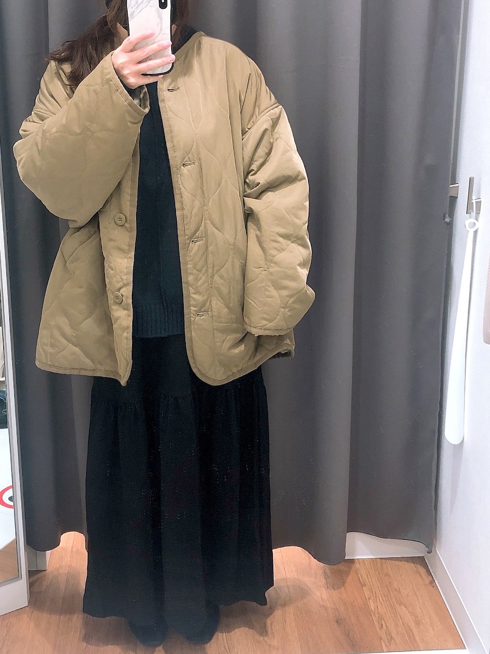 グリーン系のノーカラージャケット、ブルー系のニット/セーター、ブラック系のワンピースを着用したレディースの冬コーディネートの1枚目の写真