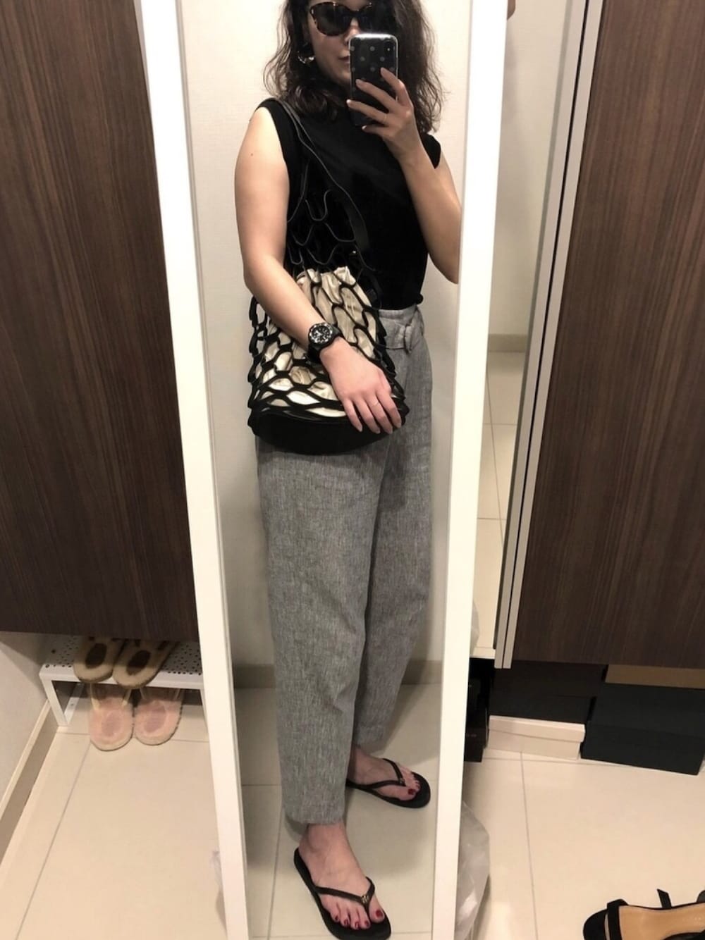 ブラック系のサンダル、グレー系のその他パンツ、ブラック系のハンドバッグを着用したレディースの秋コーディネートの1枚目の写真