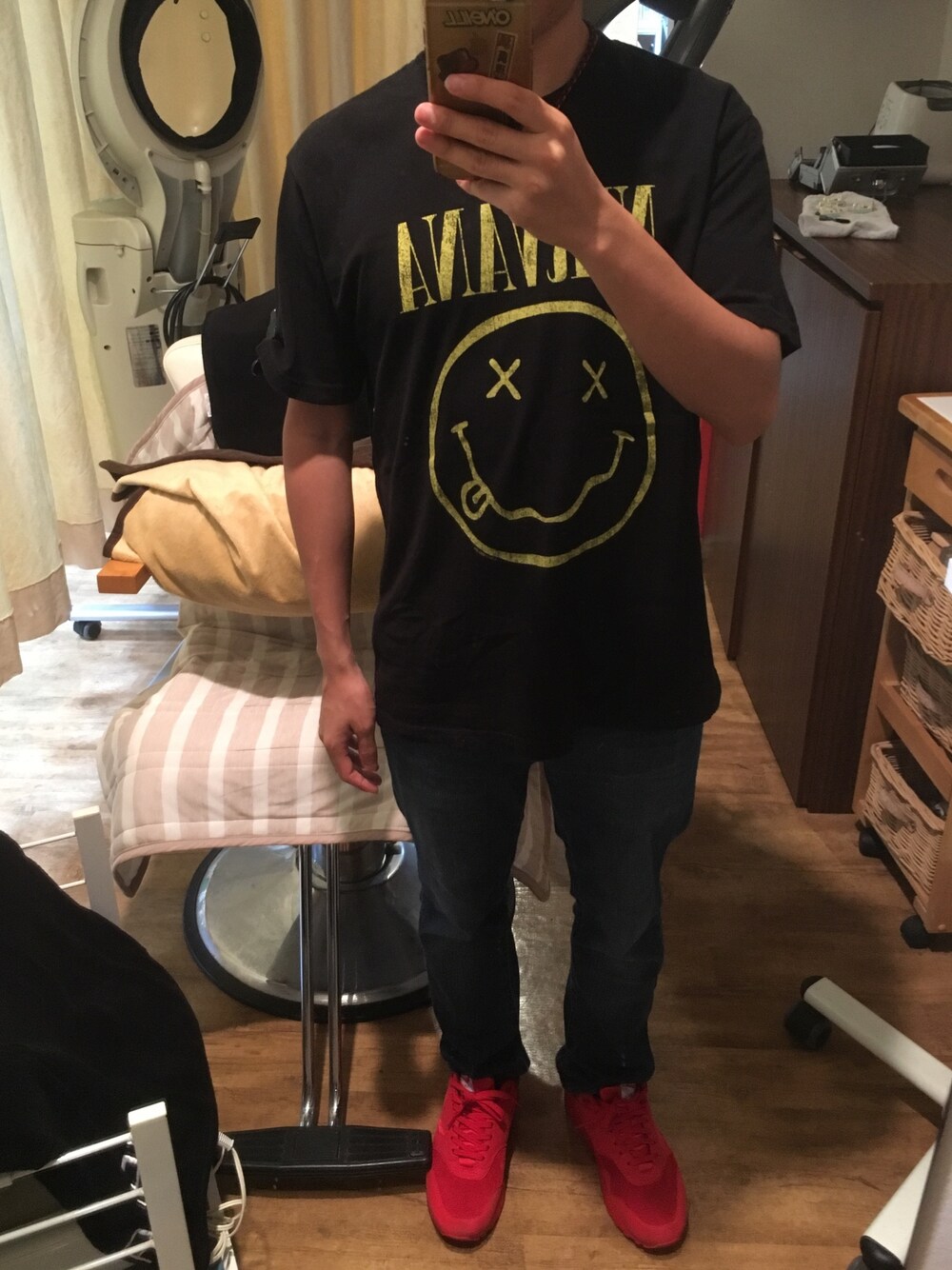 ブラック系のTシャツ/カットソー、ブルー系のデニムパンツ、レッド系のスニーカーを着用したメンズの秋コーディネートの1枚目の写真