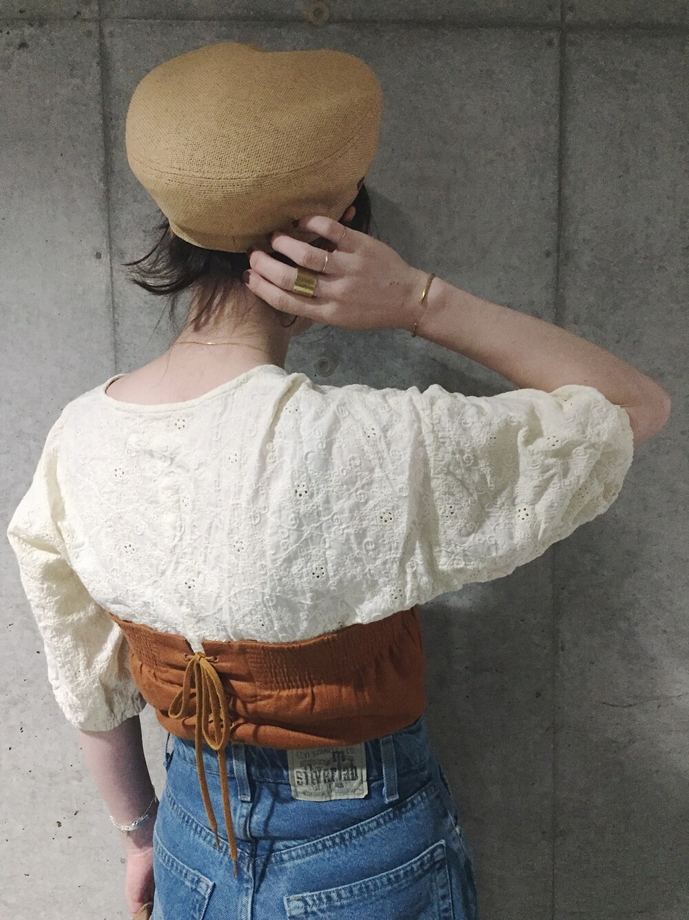 ブラウン系のその他トップス、ブルー系のデニムパンツ、ベージュ系のキャップを着用したレディースの夏コーディネートの1枚目の写真