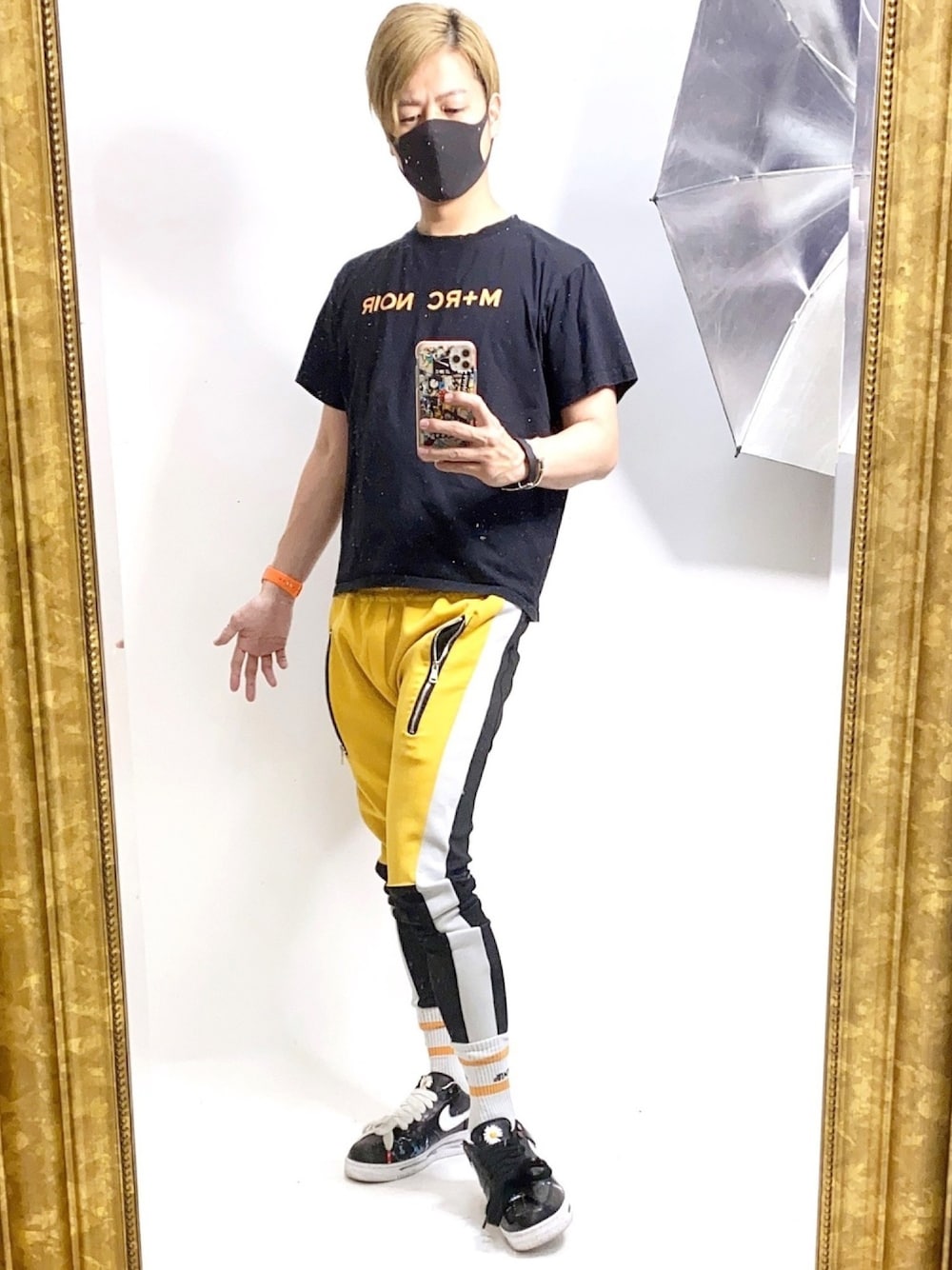 オレンジ系のTシャツ/カットソー、イエロー系のその他パンツ、ブラック系のスニーカーを着用したメンズの夏コーディネートの1枚目の写真