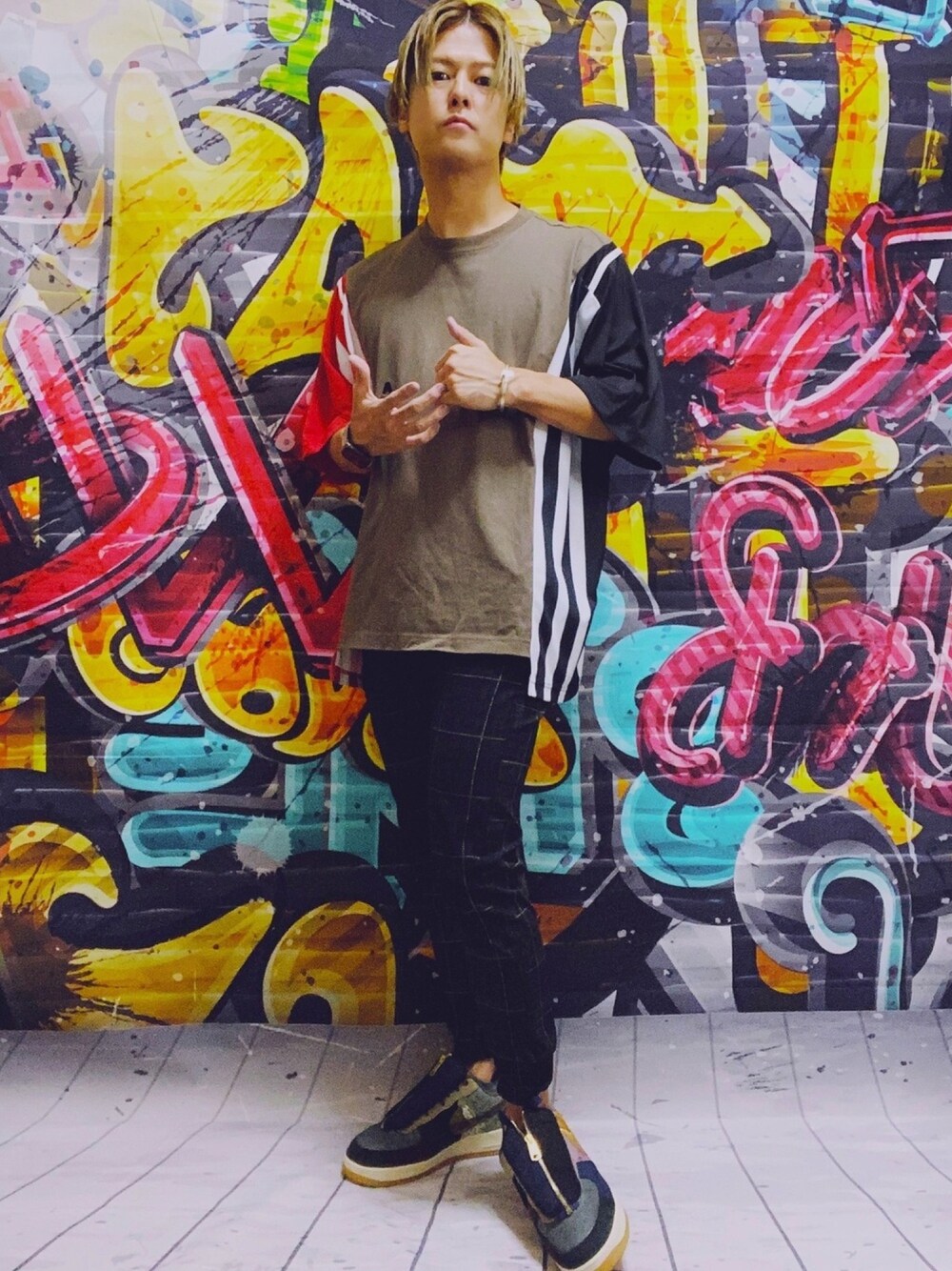 ベージュ系のTシャツ/カットソー、ブラック系のその他パンツ、ブラウン系のスニーカーを着用したメンズの秋コーディネートの1枚目の写真