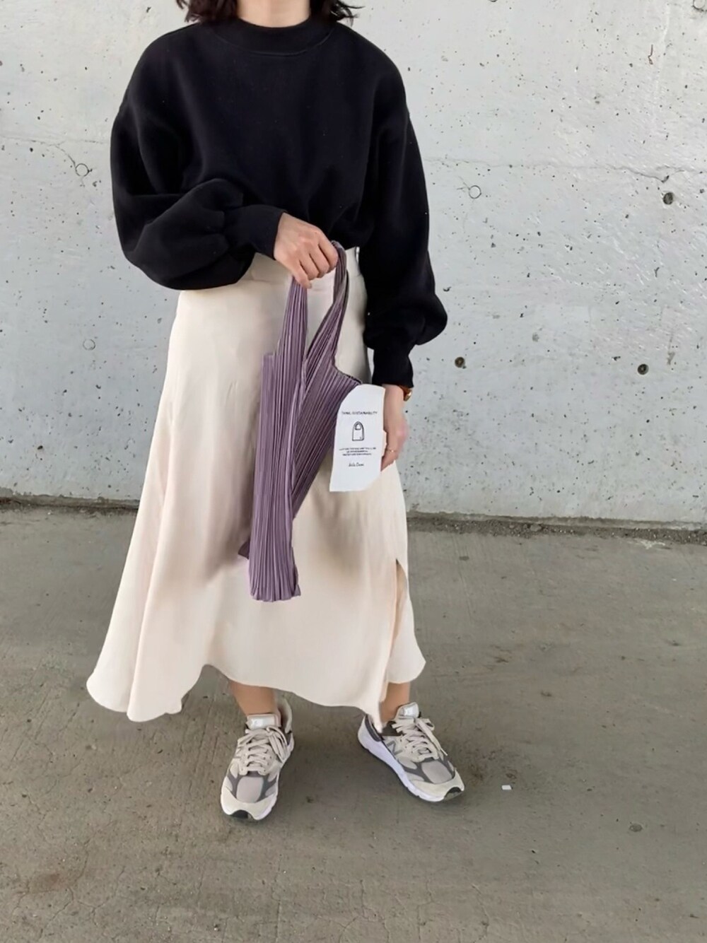 パープル系のトートバッグ、ブラック系のスウェット、グレー系のスニーカーを着用したレディースの春コーディネートの1枚目の写真