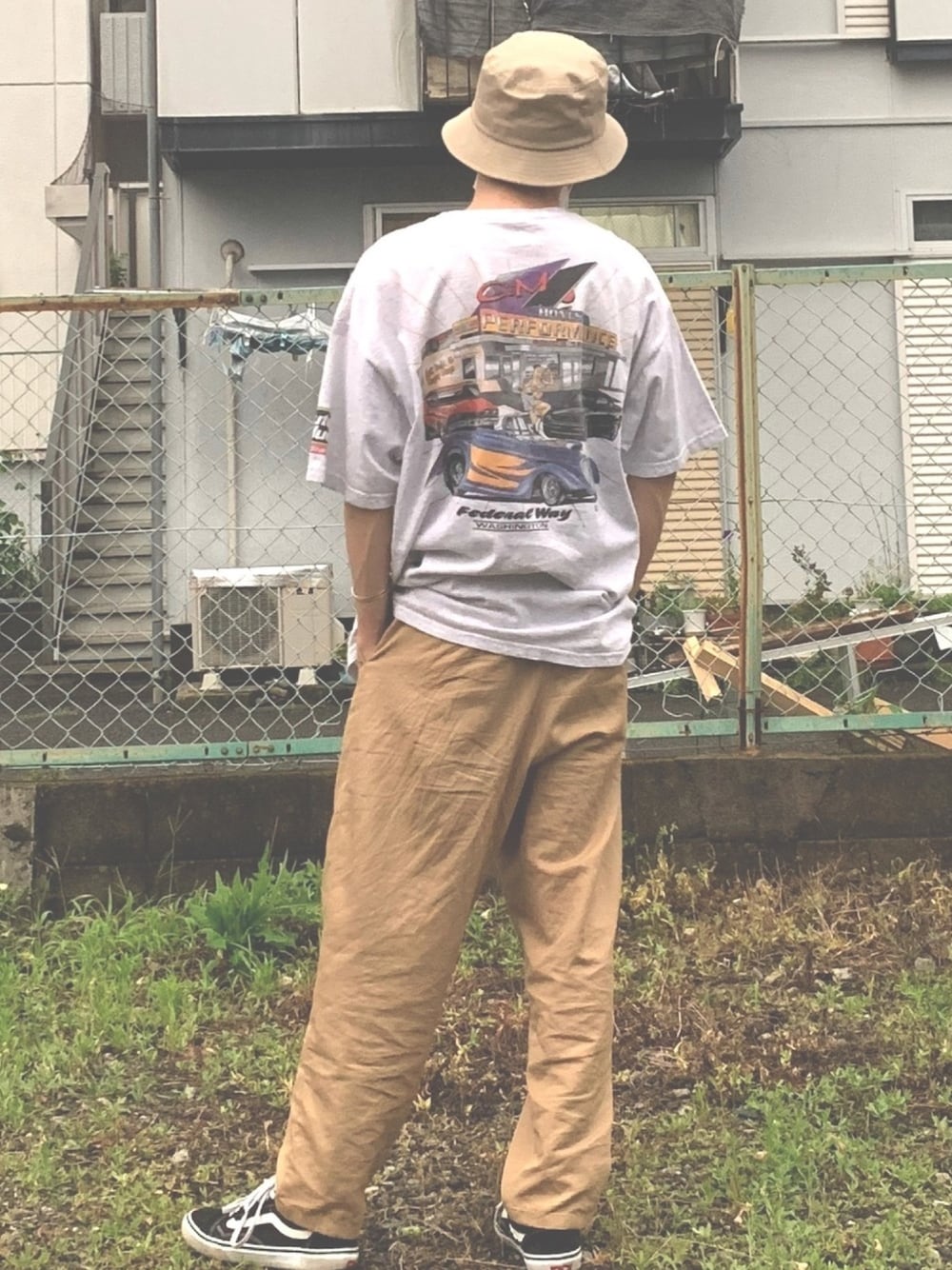 グレー系のTシャツ/カットソー、ベージュ系のチノパンツ、ブラック系のスニーカーを着用したメンズの夏コーディネートの1枚目の写真