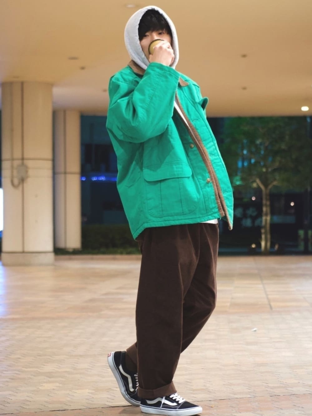 ブラック系のスニーカー、ブラウン系のパンツ、グリーン系のジャケット/アウターを着用したメンズの冬コーディネートの1枚目の写真