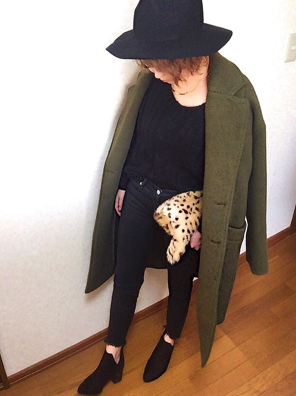 ブラック系のニット/セーター、ブラック系のデニムパンツ、グリーン系のジャケット/アウターを着用したレディースの冬コーディネートの1枚目の写真