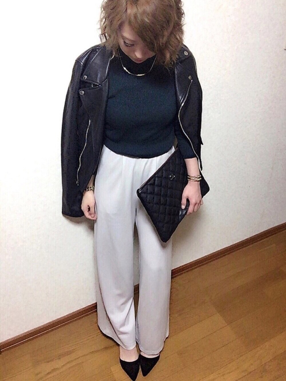 グリーン系のニット/セーター、グレー系のその他パンツ、ブラック系のライダースジャケットを着用したレディースの冬コーディネートの1枚目の写真